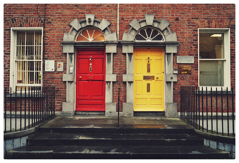 bright red and bright yellow door on red brick building in Ireland